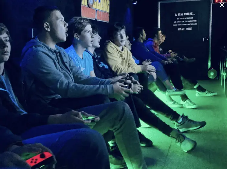 A full gaming trailer with players lined up at the screens, cheering